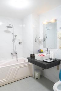 河内Moon Hotel Cau Giay的白色的浴室设有水槽和浴缸。