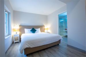 BuchillonAuberge des Grands Bois的一间卧室配有一张带白色床单和蓝色枕头的大床。