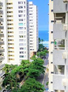 瓜鲁雅Pé na Areia a Poucos Metros -Apartamento Guarujá Pitangueiras的两座高楼和大海的空中景观