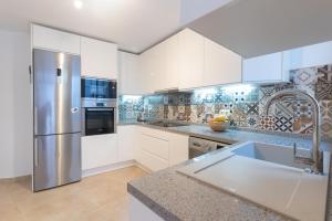 EsteponaCasa Blanca的厨房配有白色橱柜和不锈钢冰箱
