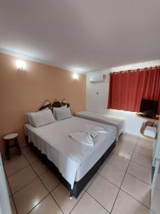 卡达斯诺瓦斯diRoma Fiori 160 Conforto e muita diversão的卧室配有一张白色大床和红色窗帘
