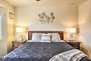 AvraSunny Tucson Home Near Saguaro Natl Park!的一间卧室配有一张带两盏灯的床。