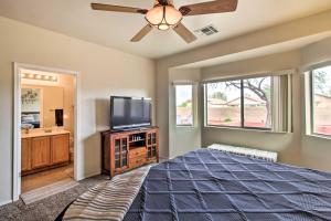 AvraSunny Tucson Home Near Saguaro Natl Park!的一间卧室配有一张床和一台平面电视