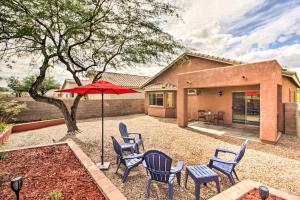 AvraSunny Tucson Home Near Saguaro Natl Park!的房屋前设有带椅子和遮阳伞的天井。