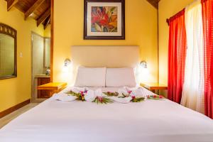 圣伊格纳西奥卡哈帕奇度假村 的卧室配有带鲜花的白色床