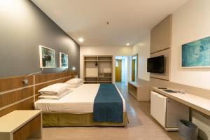 福塔莱萨Oasis Imperial & Fortaleza的配有一张床和一台平面电视的酒店客房