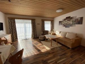 湖滨福煦朗都尔膳食公寓酒店的客厅配有沙发和桌子
