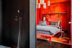 佛罗伦萨25hours Hotel Florence Piazza San Paolino的红色卧室设有一张床和淋浴