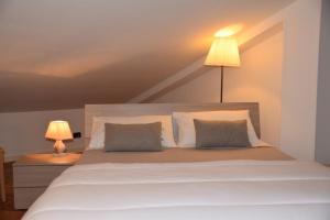 奥斯塔Appartamento Ottoz Aosta的一间卧室配有带两个枕头和一盏灯的床