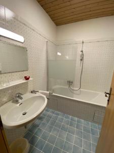 湖滨福煦朗都尔膳食公寓酒店的浴室配有盥洗盆、浴缸和盥洗盆