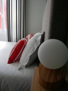 亚斯凯恩Auberge Trabenia的靠窗的一张带红白色枕头的床