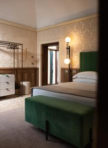 威尼斯Palazzo Maria Formosa的一间卧室配有一张大床和绿色床头板