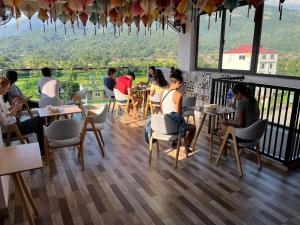 河江Ha Giang Hostel的一群坐在餐厅桌子上的人