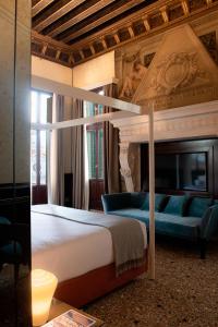 威尼斯Palazzo Maria Formosa的一间卧室配有一张特大号床和一张沙发