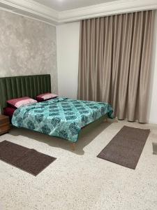 斯法克斯عمارة سيتي سنتر صفاقس的一间卧室配有一张带绿色棉被的床