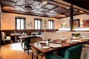 班贝格Altstadthotel Messerschmitt的餐厅设有长木桌子和椅子