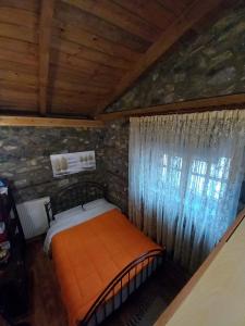 阿瑞达伊亚Loutra Mountain Nature的卧室配有一张石墙中的橙色床