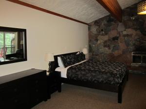 特勒斯斯基纳兰迪小屋酒店的一间卧室设有一张床和石墙