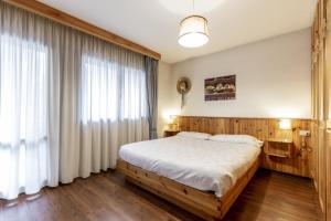 坎皮泰洛迪法萨Stella Alpina的一间卧室设有一张床和一个大窗户