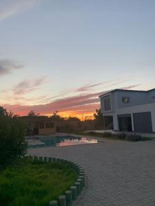 盖尼特拉Magnifique villa avec piscine的日落前带游泳池的建筑