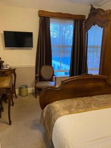 埃文河畔斯特拉特福克罗弗特宾馆的配有一张床、一张书桌和一扇窗户的酒店客房