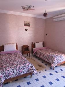 马拉喀什Marrakech Hôtel Résidence的一间卧室,配有两张床