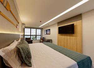 瓜拉派瑞Gaeta Hotel的一间卧室配有一张床和一台平面电视