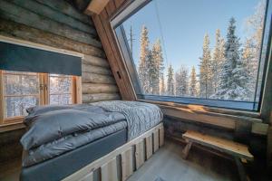 TepsaLapland Lodge的小木屋内的卧室,配有床和窗户