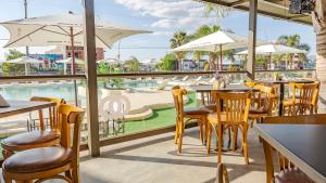维拉卡洛斯帕兹Wooden Hotel的一间带桌椅的餐厅和一个游泳池