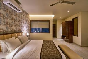 戈尔哈布尔Hotel Shlok- Pure Veg , Kolhapur的一间卧室配有一张大床和吊扇