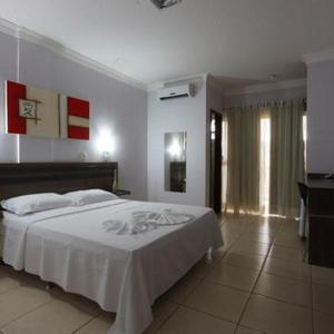 阿尔塔米拉Augustu's Hotel的卧室配有白色的床和电视。