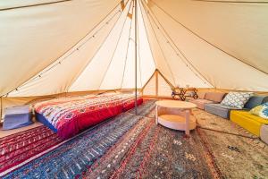 仓敷OKAYAMA GLAMPING SORANIA - Vacation STAY 73233v的帐篷配有床、桌子和地毯