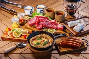 仓敷OKAYAMA GLAMPING SORANIA - Vacation STAY 73233v的餐桌上满是食物,还有一壶食物和肉