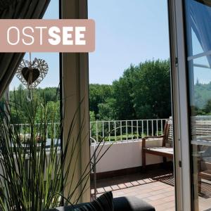 哈里斯莱Ostsee, wunderschöne Wohnung mit Meerblick的通往阳台的开放式门,阳台享有庭院美景