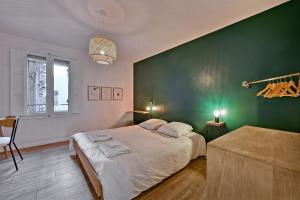 阿维尼翁Aux MARCHES DU PALAIS - AC CLIM - SPACIEUX - TERRASSE - WIFI的一间卧室设有一张大床和绿色的墙壁