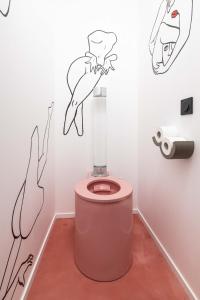 罗科福尔拉贝杜勒Minamina, chambre avec jacuzzi privatif的浴室设有粉红色的卫生间,墙上挂着绘画。