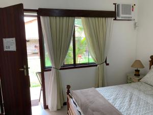 卡波布里奥Pousada Fazendinha Unamar的一间卧室设有一张床和一个大窗户