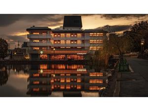 奈良Hotel Tenpyo Naramachi - Vacation STAY 59515v的一座建筑物,其灯光反射在水中