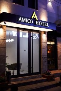 普里什蒂纳Amico Hotel的建筑一侧的美 ⁇ 酒店标志