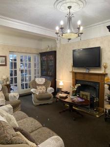 埃文河畔斯特拉特福克罗弗特宾馆的客厅设有壁炉和电视。