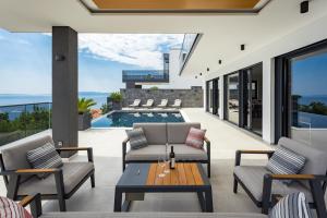 奥帕提亚Villa Titanium的一个带桌椅的户外庭院和一个游泳池