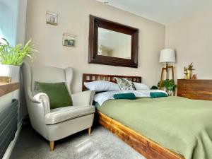 西部德比Luxury Oriental Home with Exotic Garden & Free Parking的一间卧室配有一张床、一把椅子和镜子