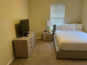 托皮卡WASHBURN HOTEL SUITES的一间卧室配有一张床和一台平面电视