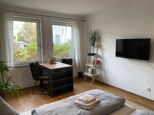 马格德堡RR - Tiny Apartment - Parking - Kitchen - Netflix的客房设有床、书桌和电视。