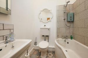 兰代洛Goilan Goch的浴室配有卫生间、浴缸和水槽。