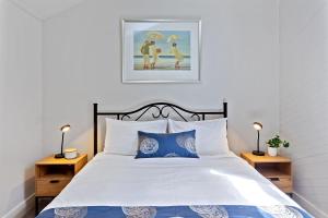 阿波罗湾Whitecrest Eco Apartments Great Ocean Road的一间卧室配有一张带蓝色和白色枕头的床