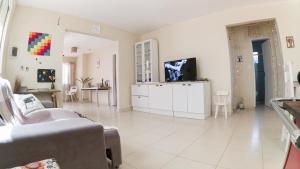 巴拉奈里奥-坎布里乌Casa Familiar Estaleiro的带沙发和电视的客厅