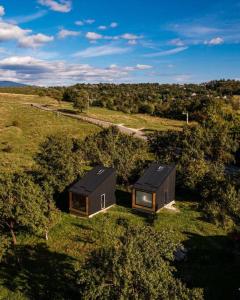 肯普隆格Campolongo Tiny Chalet的田野上两座小房子的头顶景色