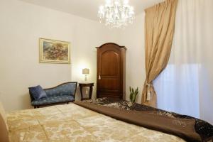圣马力诺B&B Old Town San Marino的一间卧室配有一张床、一把椅子和一个吊灯。