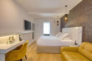 里尔Boa Hotel - BW Signature Collection - Lille Centre Gares的酒店客房配有白色的床和沙发。